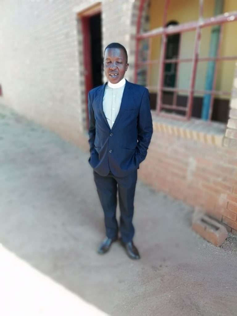 Rev. Daniel Vusi Mathe, Pastor 2010-2022, next to the new church structure